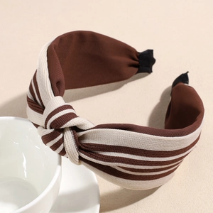 Detail of striped knitted headband featuring a brown and beige knotted fabric design