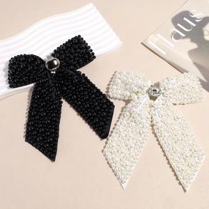 Elegant bow hair clip with luxury pearls and rhinestone center available in black and white