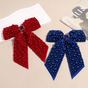 Elegant bow hair clips with pearls and rhinestones in vibrant red and royal blue colors