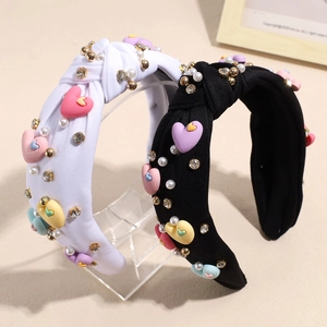 Baroque knotted headbands with rhinestones, pearls and colorful hearts on white display
