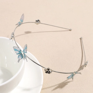 Macro detail of silver zinc alloy headband featuring blue butterflies and metal flowers