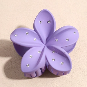 Détail d'une pince à cheveux fleur mate violette avec des strass étincelants