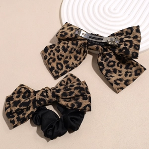 Haarclip met luipaardstrik en scrunchie set op minimalistische beige achtergrond