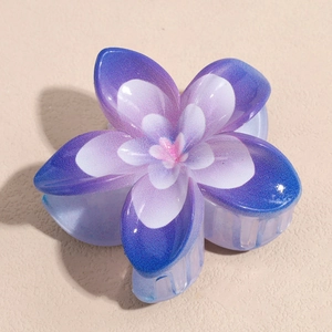 Détail de la pince à cheveux fleur dégradé violet avec paillettes et texture résine