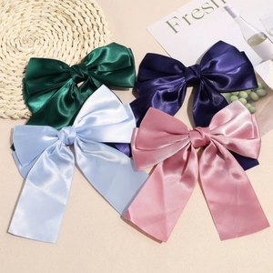 Detail view of large satin double bow hair clips in four elegant assorted colors