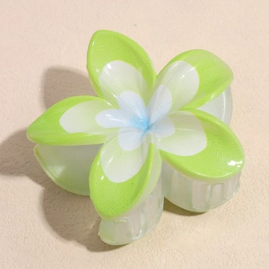 Détail d'une pince à cheveux plumeria avec pétales en résine dégradé blanc et vert