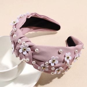 Detail of pink knotted fabric headband with 3D white daisy flowers and white pearls