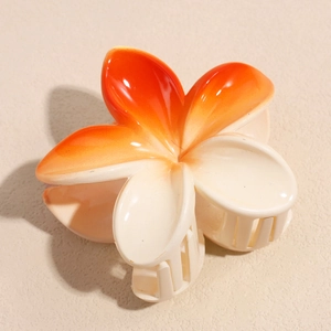 Macro detail of a candy-colored gradient flower hair claw clip with orange finish