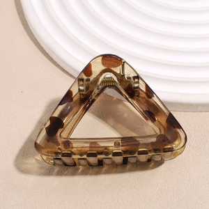 Macro detail of amber tortoise shell hair claw clip with sturdy metal spring mechanism
