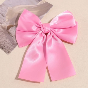 Close-up of pink satin double-layered bow hair clip with elegant long ribbons