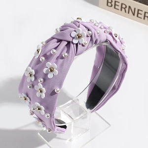Detail of lavender knot headband with white floral resin charms and scattered pearls