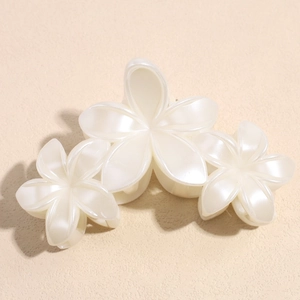 Détail de la pince à cheveux élégante avec fleurs de lys et fini blanc perlé