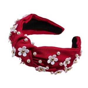 Elegant red knotted headband with white resin flowers and pearls on white background