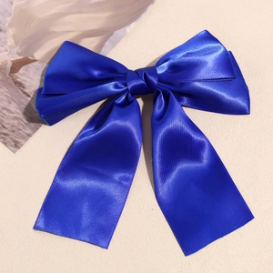 Detail shot of royal blue satin double-layered bow hair clip with long flowing streamers