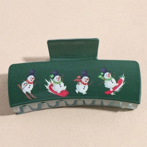 Detail of dark green matte hair claw with festive skiing snowman illustration