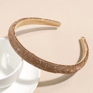 Close-up of champagne brown headband with shimmering rhinestones on a white cup