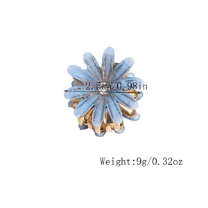 Makroaufnahme der blauen Gänseblümchen-Haarklammer mit Strass und goldener Kralle
