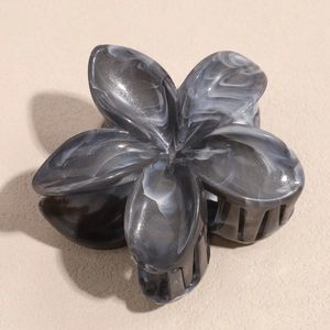Detail view of the acetate plumeria hair claw clip with elegant grey marble pattern