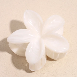Macro detail of elegant marble texture plumeria hair claw clip with pearlescent finish