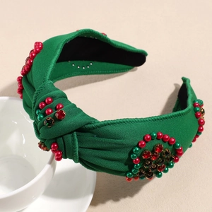 Detail eines Weihnachtsknoten-Stirnbands mit roten und grünen Perlen und Strasssteinen