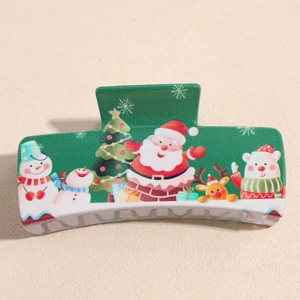 Detail of green Christmas hair claw clip featuring Santa and Reindeer cartoon patterns