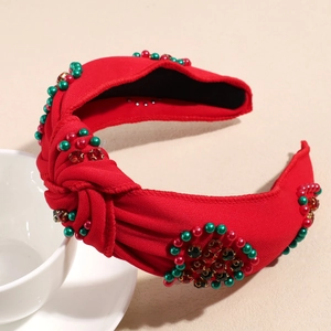 Detail eines roten Knotenstirnbands mit Perlen und Strasssteinen für Weihnachten