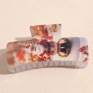Close-up of large hair claw clip with festive Santa Claus and Christmas tree patterns