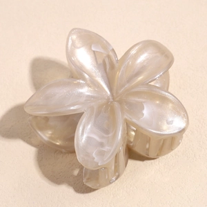 Detailed macro view of the champagne marble texture on the elegant plumeria hair claw clip