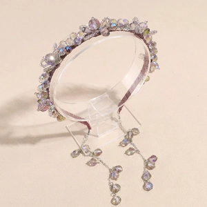 Gros plan détaillé d'un serre-tête en perles de cristal avec pompons sur présentoir