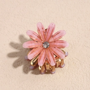 Detail von rosa Gänseblümchen-Haarklammer mit glitzernden Strasssteinen und goldenem Clip
