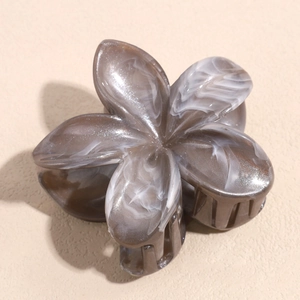 Detail view of flower hair claw with gray marble texture and polished acetate finish