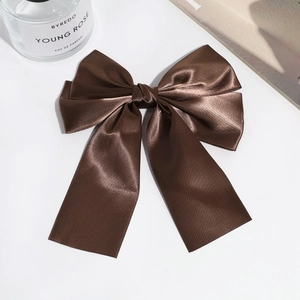 Detail view of a premium dark brown satin double-layer bow hair clip with silky texture