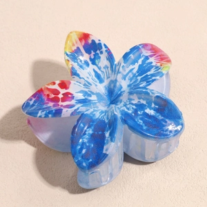 Detail of blue floral hair claw clip with colorful tie-dye patterns and resin texture
