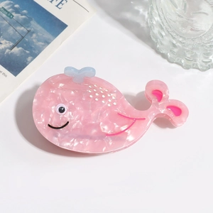 Pink whale-shaped acetate hair claw clip with marble texture on a white background