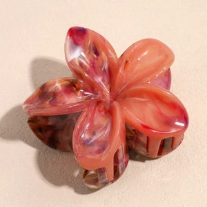 Detailed close-up of the elegant marble-textured plumeria flower claw clip in purple and red
