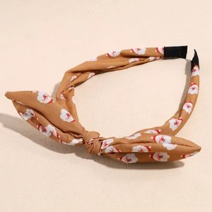 Dettaglio della fascia di Natale con stampa Babbo Natale e design con fiocco a nodo
