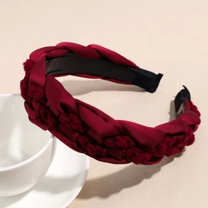 Detail of burgundy braided headband with satin and knit fabric textures for women