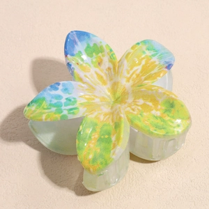 Detailed close-up of a large floral hair claw clip featuring blue and yellow watercolor print