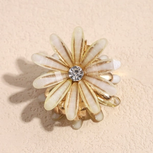 Makro-Detail der Gänseblümchen-Haarklammer mit zentralem Zirkon und glitzernden Blütenblättern