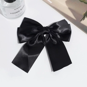 Detailed view of the layered black satin bow hair clip with elegant glossy silk texture