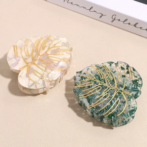 Leaf-shaped acetate hair claws with gold vein texture in cream pink and dark green