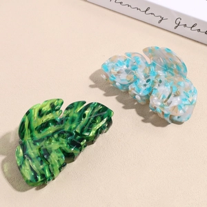 Leaf-shaped acetate hair claws with marble texture in green and blue-white colors