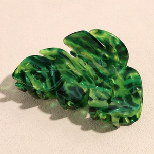 Detail of leaf-shaped acetate hair claw clip with green marble texture finish