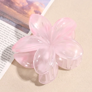 Macro detail of a pink translucent resin flower hair claw clip on a decorative background