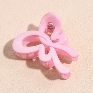 Close-up of a sweet pink bow hair claw clip with a glossy finish and metal spring