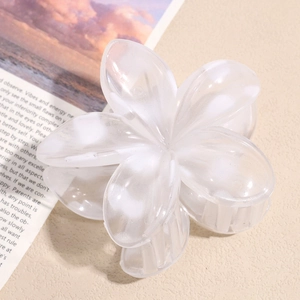 Macro detail of a translucent cream floral hair claw clip on a stylish magazine background