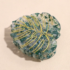 Close-up of monstera leaf hair claw clip with green marble acetate and gold veins