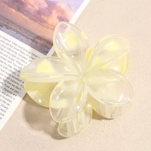 Detailed view of yellow resin flower hair claw clip with pearlescent finish and metal spring