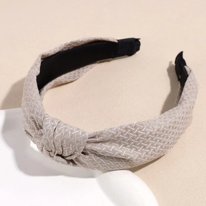 Détail d'un serre-tête noué beige clair avec motif à chevrons et doublure intérieure noire