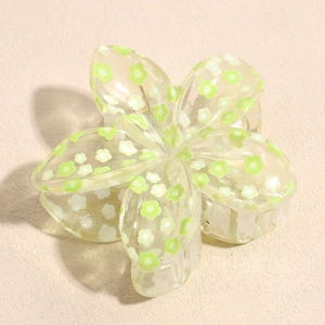 Dettaglio macro della molletta per capelli a forma di fiore con glitter e motivi